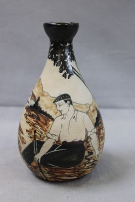 a black and white vase with a picture of a man sitting on a bench