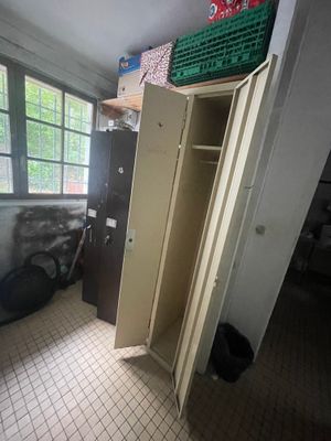 une armoire haute au milieu d'une pièce avec une fenêtre
