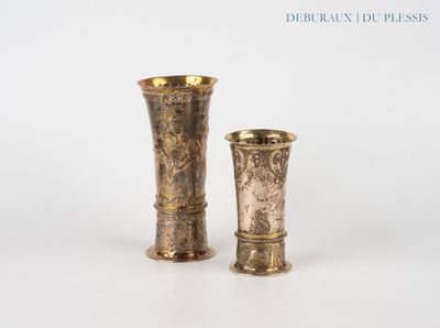 deux vases en or posés l'un à côté de l'autre sur une surface blanche