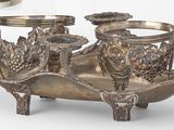 trois vases en argent et un plateau en argent posés sur une table