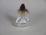 a small glass figurine with a purple flower in it