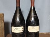 two bottles of wine sitting on top of a wooden table