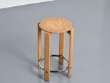 a wooden stool with a metal ring on it