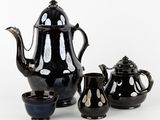 des théières et des tasses noires et blanches posées sur un fond blanc
