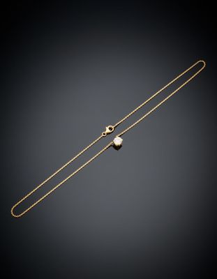 un collier en or orné d'une perle sur fond noir