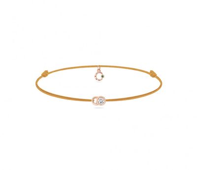 un bracelet en or orné d'un diamant blanc et d'une pierre verte