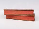 two books stacked on top of each other on a white surface