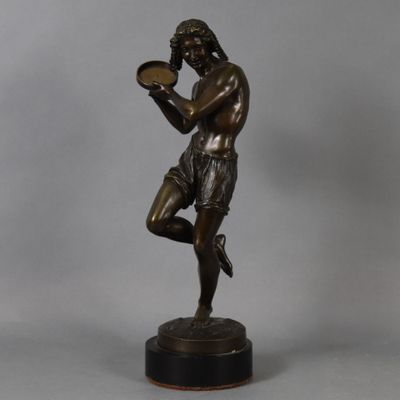 a bronze statue of a man holding a tray