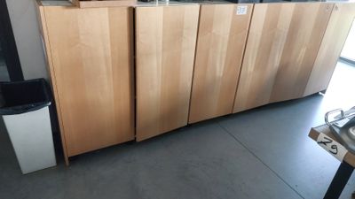 many wooden cabinets in a room with a stove and sink