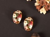 three pieces of art glass with flowers and shells on a black surface