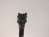 someone is holding a cane with a dog head on it