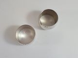 two silver cups sitting on a white surface