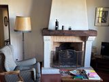 a living room with a couch, chair, table and fireplace