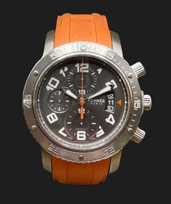une montre orange avec un cadran noir sur fond noir