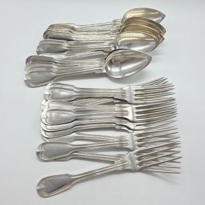 Plusieurs cuillères et fourchettes sont disposées en rangée sur une surface blanche