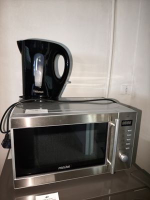 a coffee pot on top of a microwave on top of a counter