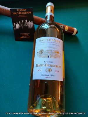 une bouteille de vin blanc et un cigare posés sur une table