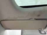 a dirty seat in the back of a car with a window open