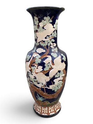 un vase bleu orné d'un oiseau et de fleurs