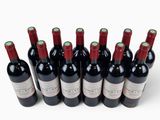 six bottles of red wine lined up on a white surface