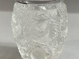 un vase en verre transparent muni d'un couvercle, posé sur une table