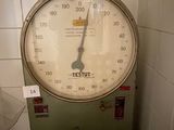 une grande balance avec une horloge dessus dans une salle de bains