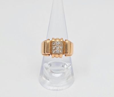 une photo d'une bague en or et diamants posée sur un socle en verre transparent