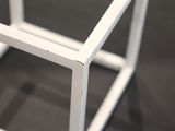 a white metal frame with a small square on top