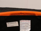 a black bag with an orange handle and a label on it