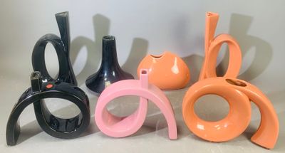quatre vases de couleurs différentes et une paire de ciseaux sur la table