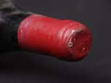 a close up of a bottle of wine with a red cap