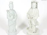 pair of white statues of a woman and a man on a pedestal