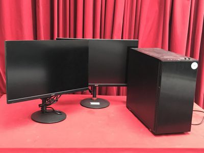 deux écrans d'ordinateur posés sur une table rouge, avec des rideaux rouges