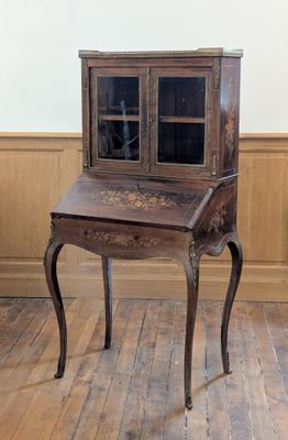 un petit bureau en bois surmonté d'une porte vitrée