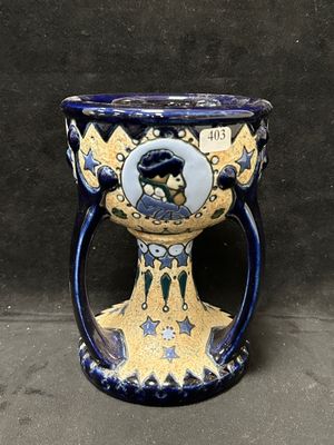 un vase bleu et jaune sur lequel est représenté un homme