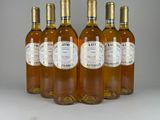four bottles of wine are lined up on a white surface