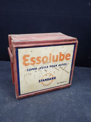 Une vieille enseigne « Essolube » est posée sur une table