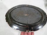 a hand holding a silver plate with a hole in it