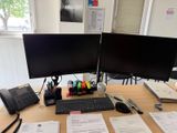 un bureau équipé de deux écrans et d'un clavier