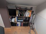 a book shelf in the corner of a room with books on it