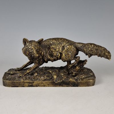 une image représentant une statue en bronze d'un renard posé sur un rocher