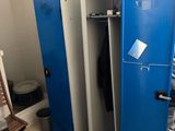 plusieurs casiers bleus dans une pièce où se trouvent une chaise et une chaise