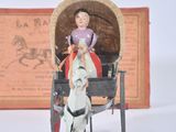 a figurine of a woman riding in a horse drawn carriage