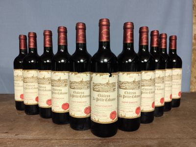 six bottles of red wine are lined up on a wooden table