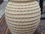 a large vase sitting on a rug on the floor