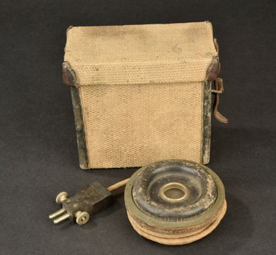 an old fashioned camera with a canvas case and a metal object