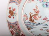 a close up of a plate with a bird and flowers on it