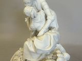 a statue of a man and a woman sitting on a rock