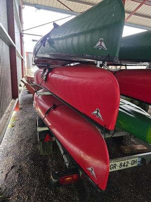 de nombreux canoës empilés les uns sur les autres dans un hangar