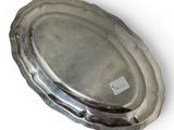an oval silver tray on a white background with a tag